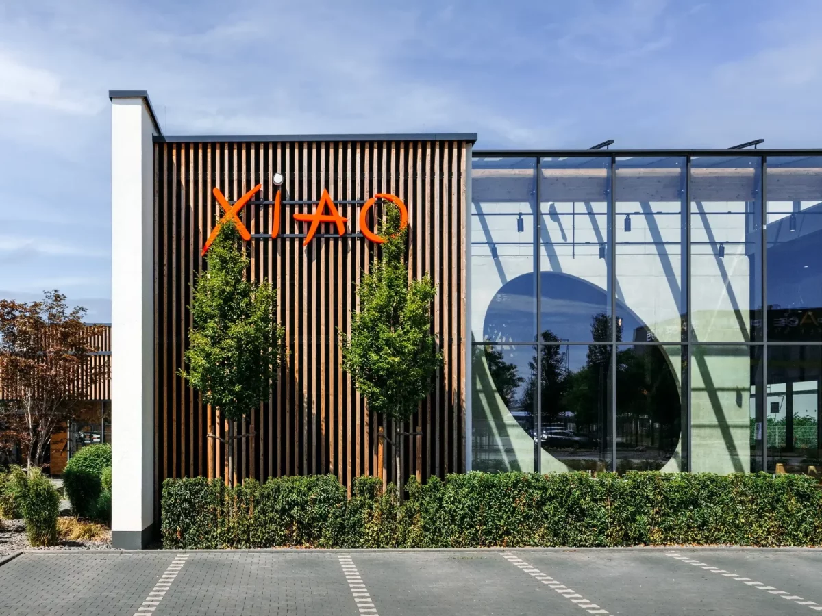 Ein modernes Glasgebäude mit XIAO-Logo und Parkplatz