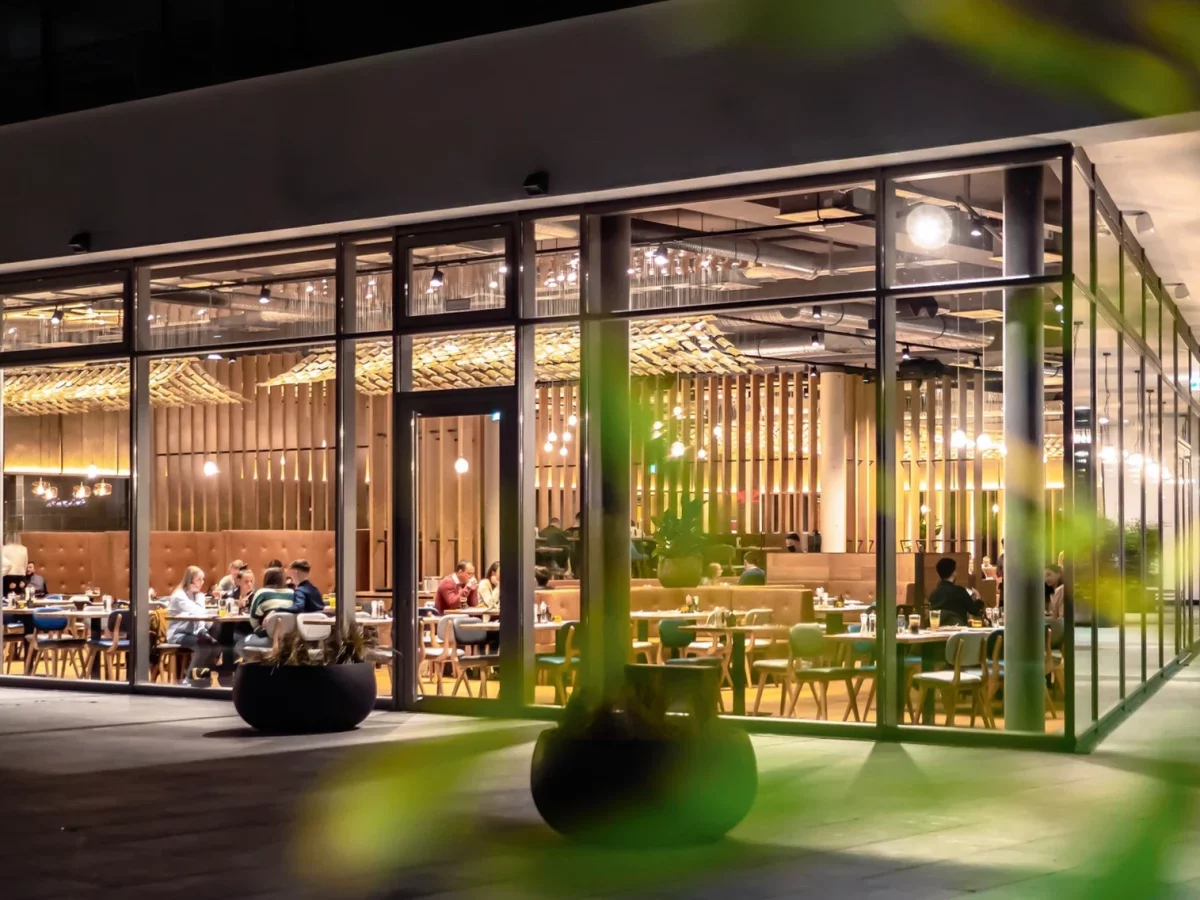 Ein stylishes Restaurant mit Glasfassade in stimmungsvollem Licht